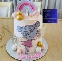 A pastel fairy cake with a rainbow topper and the name Lethabo